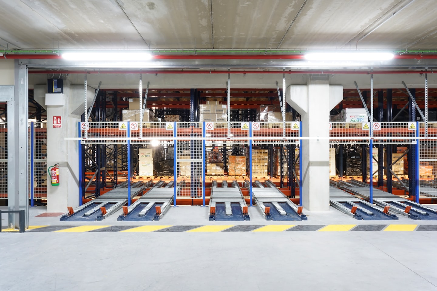 Magazzino automatizzato con scaffalature per pallet e sistemi di trasporto.