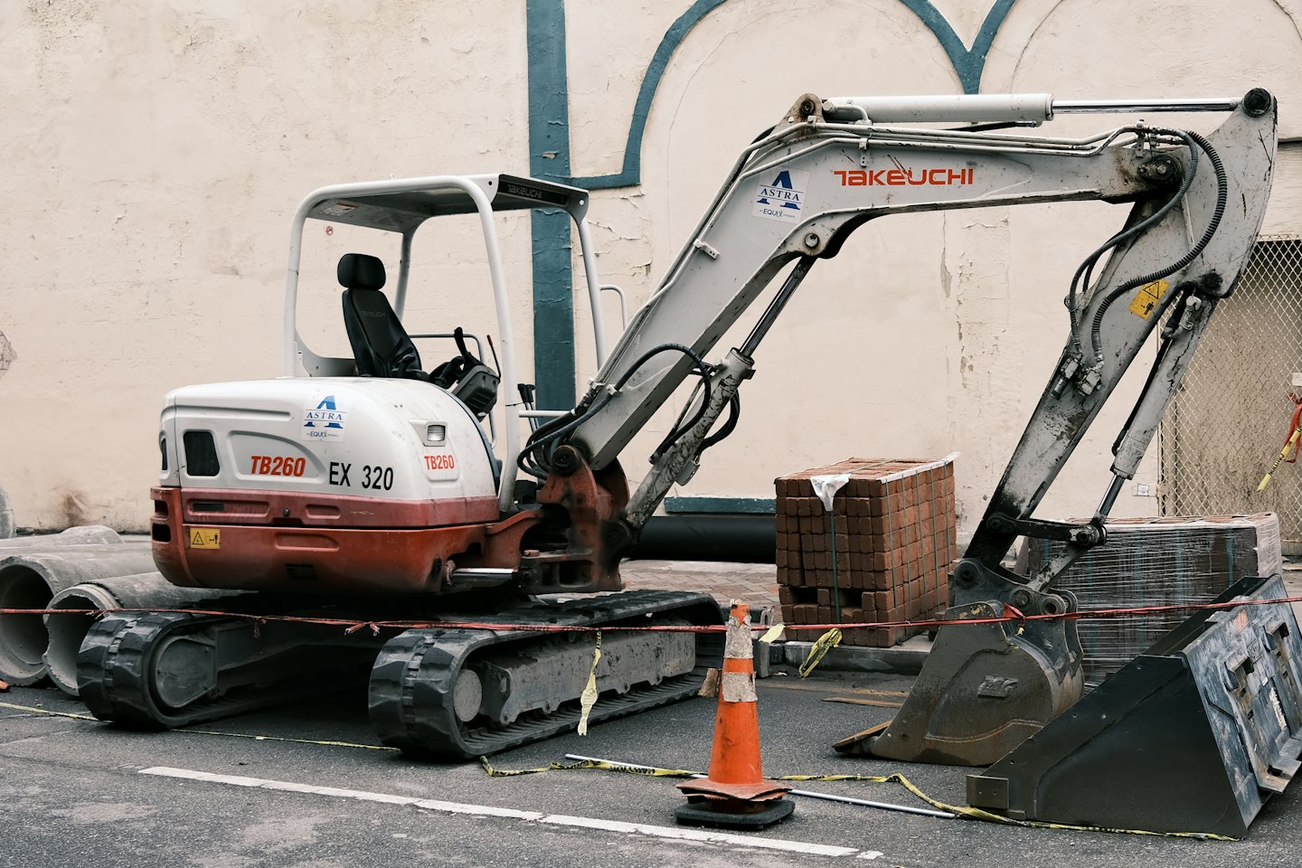 Un escavatore da cantiere parcheggiato su una strada asfaltata.